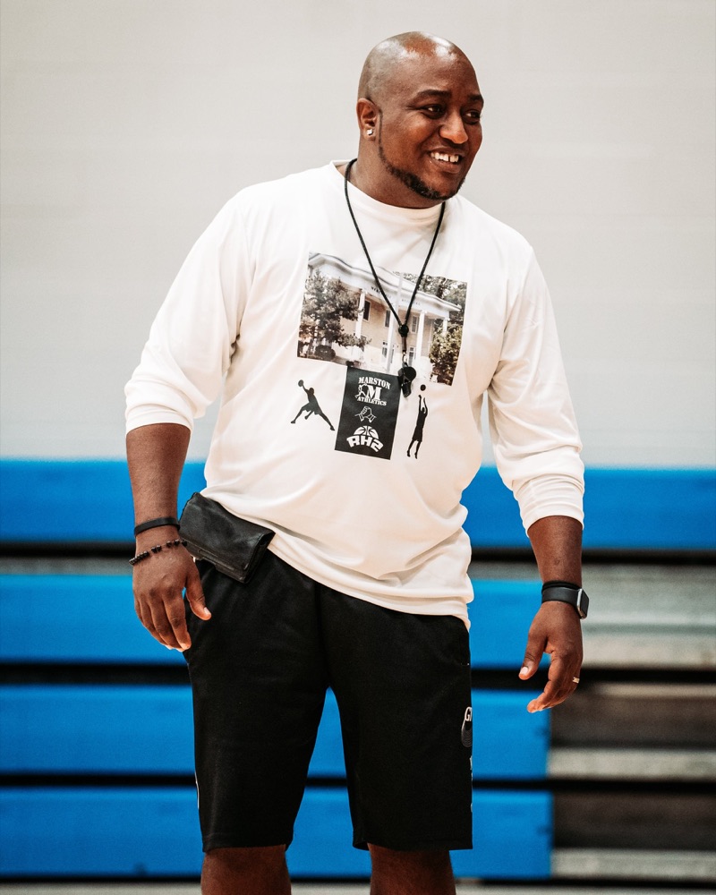 Coach Pete Marston smiling on the court