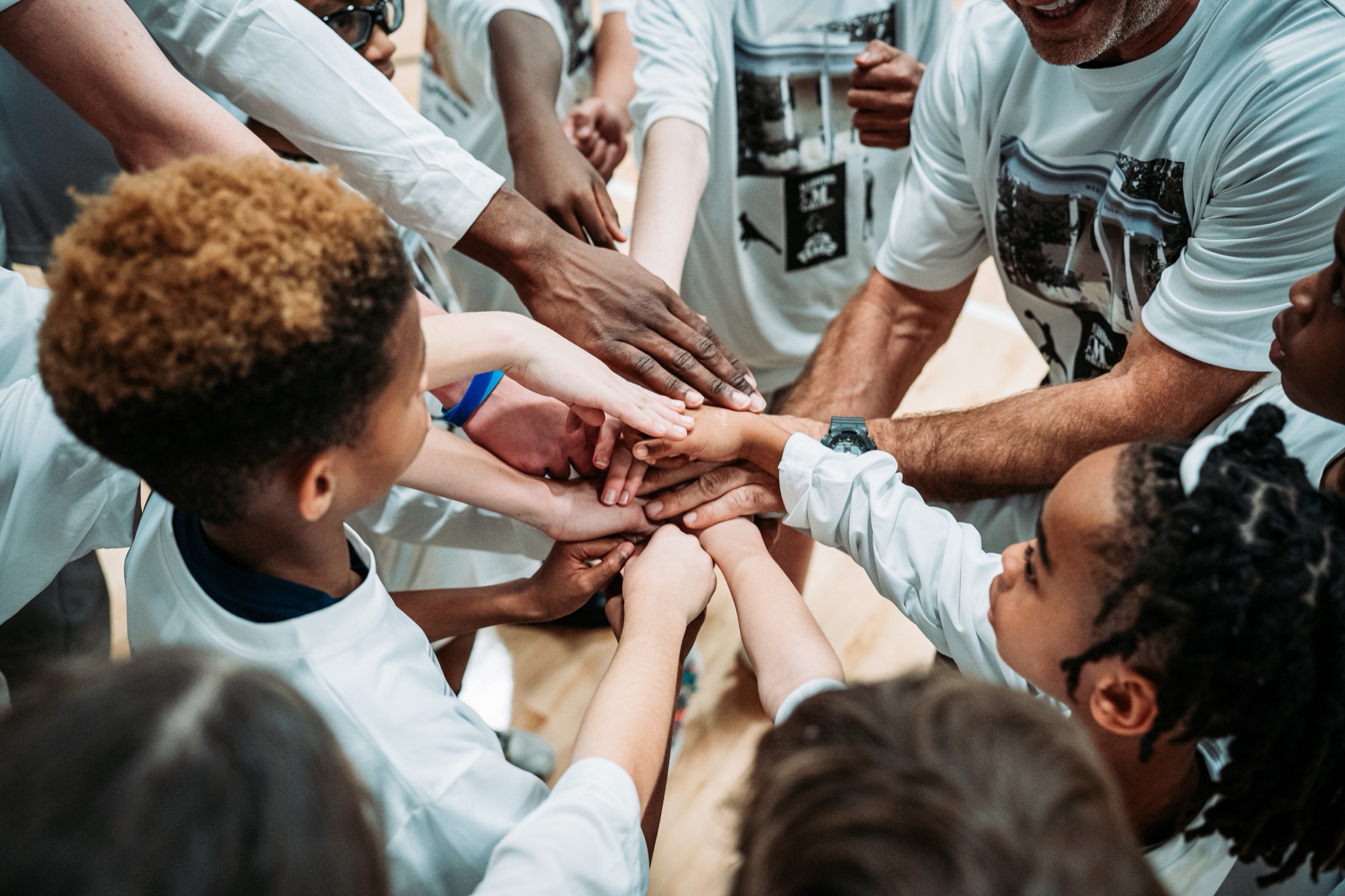 Marston Athletics players and coaches stacking hands in a huddle